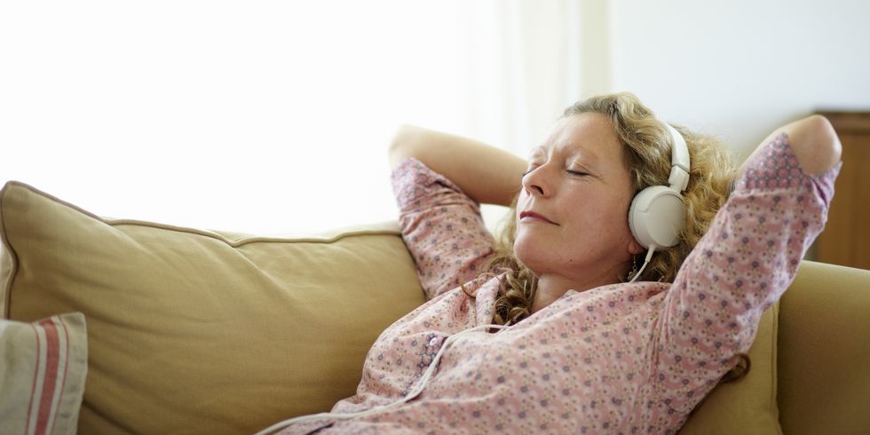 Woman relaxing on sofa listening to music
