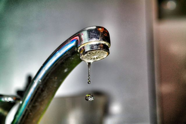 Close-Up Of Water Droplet Dripping From Kitchen Faucet