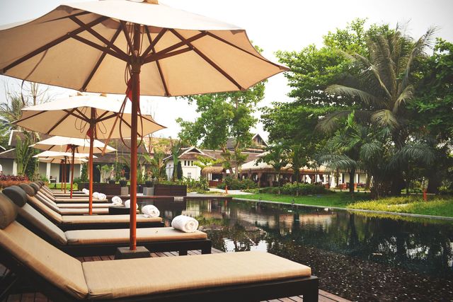 Outdoor furniture, Umbrella, Resort, Shade, Outdoor table, Pond, Reflection, Patio, Sunlounger, Resort town, 