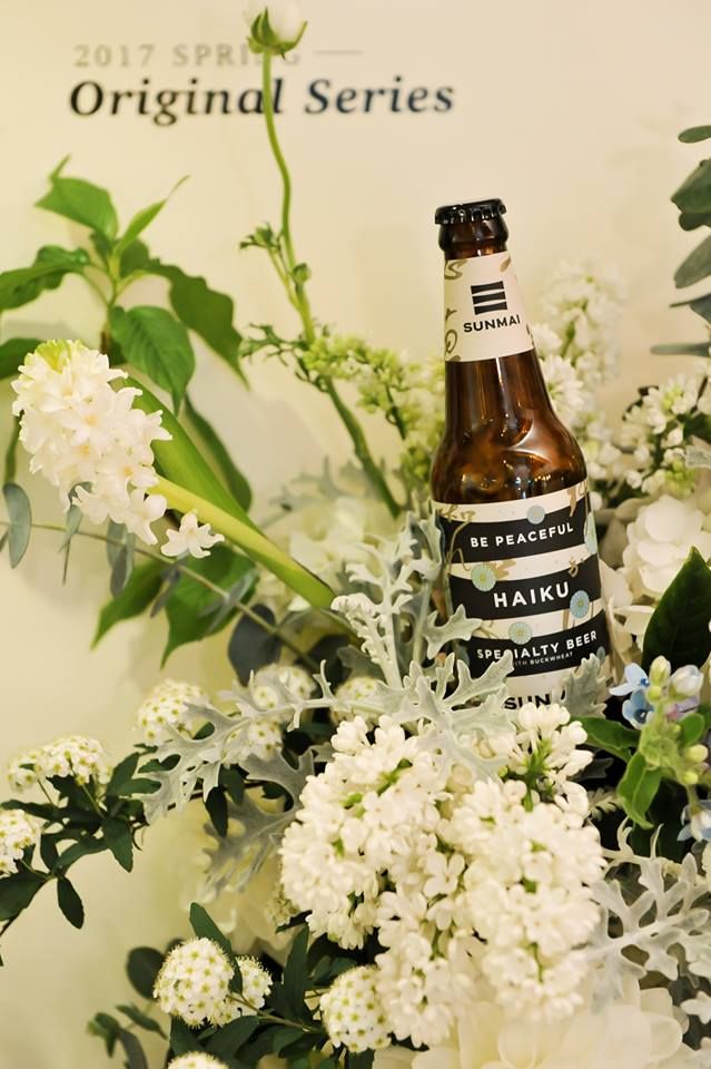 Glass bottle, Bottle, Drink, Flower, Petal, Alcoholic beverage, Logo, Flowering plant, Beer bottle, Bottle cap, 