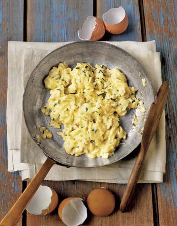 scrambled eggs with chives in a pan