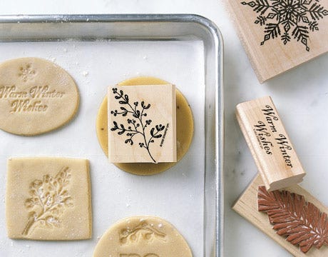 a tray of sugar cookie cutouts surrounded by rubber stamps a tray of sugar cookie cutouts surrounded by rubber stamps