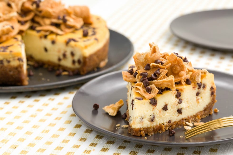 cheesecake topped with cannoli shells and studded with chocolate chips, like a cannoli