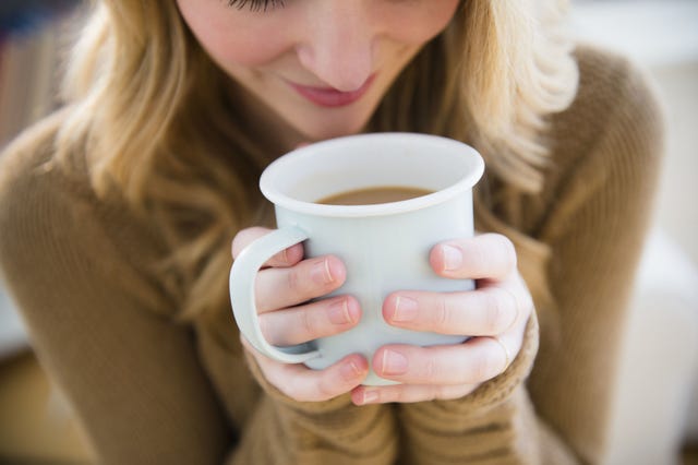 Woman in sweater holding coffee mug