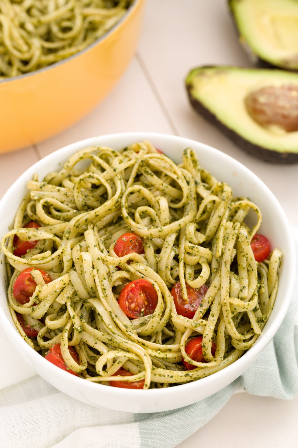 avocado pesto fettuccine with tomatoes in a bowl