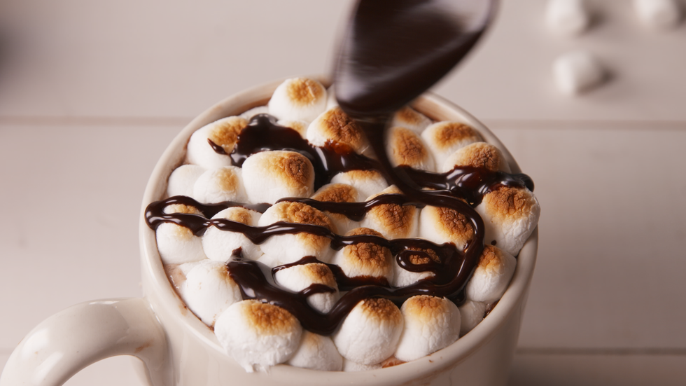 Drizzling hot fudge on hot chocolate