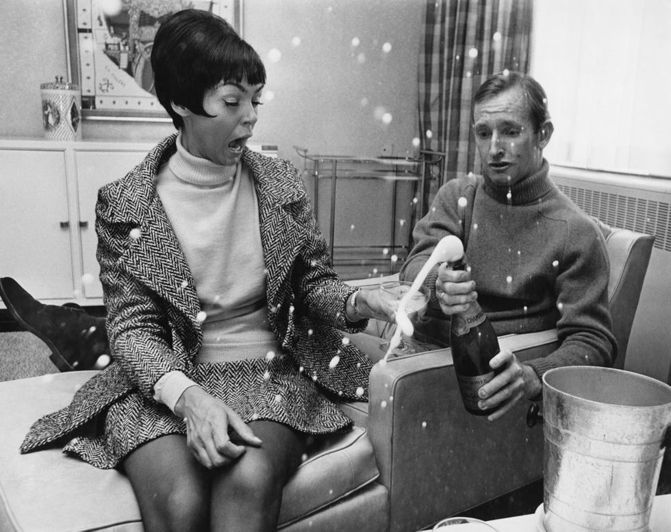 Leg, Sitting, Furniture, Conversation, Curtain, Vintage clothing, Shelf, Living room, Handbag, Retro style, 