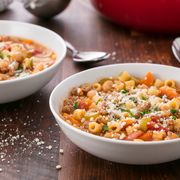 two bowls of pasta fagioli topped with fresh parmesan cheese
