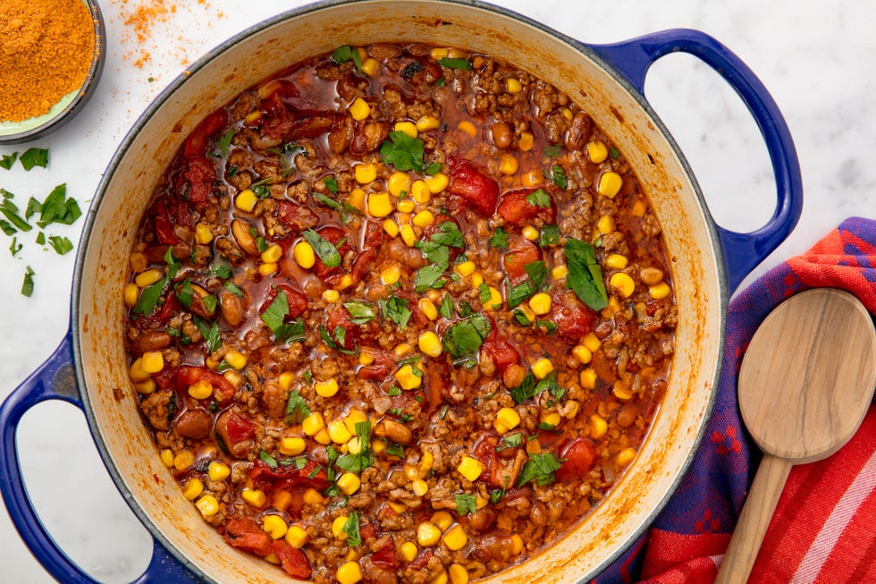 a pot of taco soup filled with ground beef, onions, tomato, beans and corn