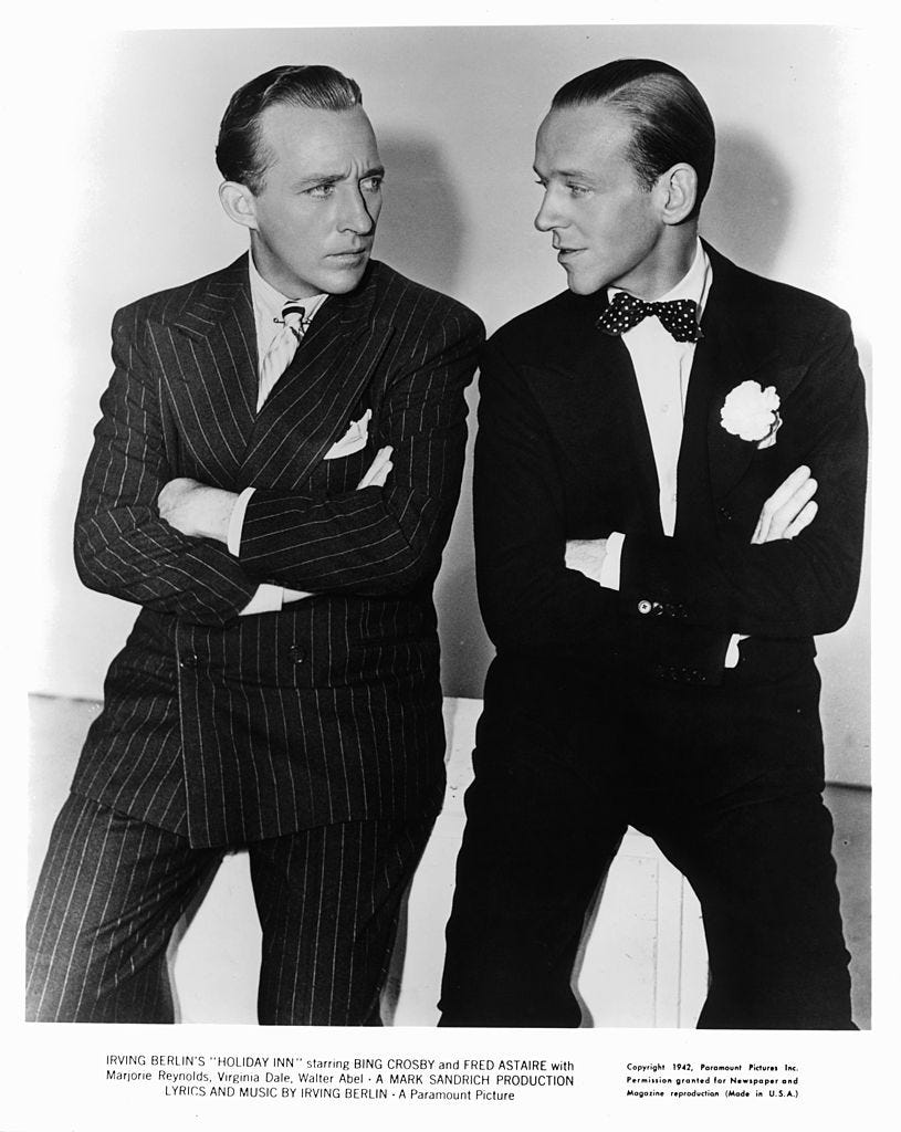 bing crosby and fred astaire with their arms folded staring at one an other in a scene from the film 'holiday inn', 1942