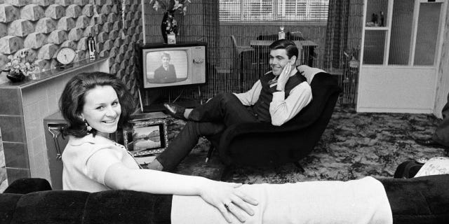 Celtic footballer John Hughes at home with his wife, 1968