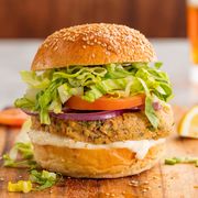 salmon burgers with red onion, tomato, lettuce, on a seeded bun