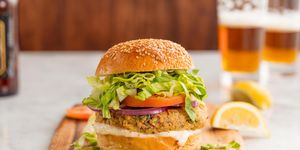 salmon burgers with red onion, tomato, lettuce, on a seeded bun
