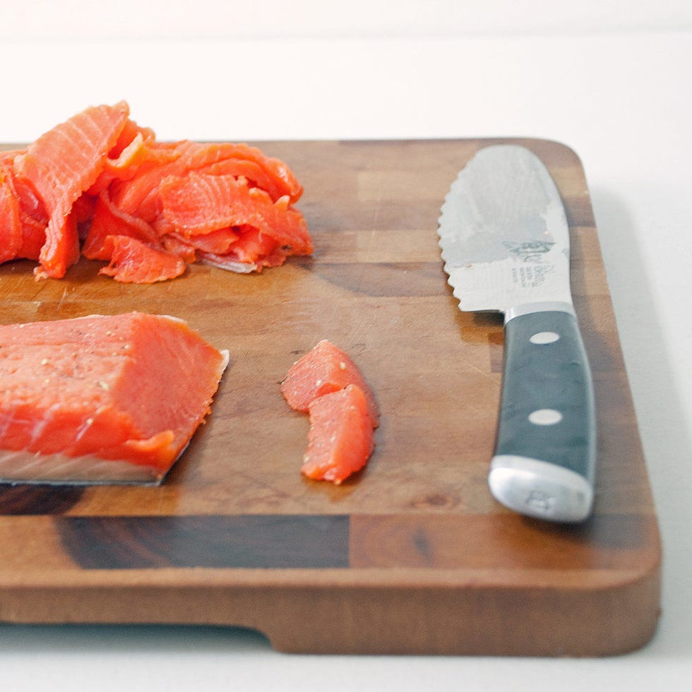 <p>Rinse the gravlax to remove the curing mixture, pat it dry, and set it on a cutting board. Split the fillet in half along the center indent to make it easier to work with. For each half, start slicing the gravlax on a bias by slicing off a small chunk at an angle. Then, slice it as thinly as you can manage at that angle through the remainder of the fillet.</p>
