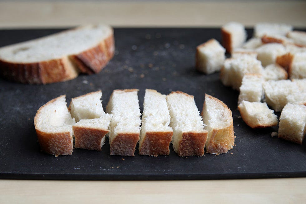 Cut each slice into 1-inch-wide strips, then cut each strip into 1-inch cubes. Alternatively, tear the bread into chunks that are roughly 1-inch by 1-inch.