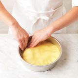 <p>Tuck the pastry carefully and evenly down the sides of the dish — this will form the pastry base when the pie is inverted.</p>