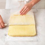 <p>Place the cake on a piece of sugared baking paper and gently peel away the lining paper, using a spatula to press down on the paper. The weight of the spatula will prevent the sponge from breaking.</p>