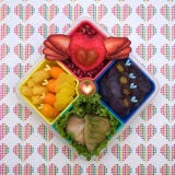 A few dumplings and a rainbow of fruits and vegetables take flight in this bento box.