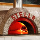 Pizzeria Stella; Philadelphia At restaurateur Stephen Starr's Neapolitan pizzeria, the Renato oven (the same brand that star pizzaiolo Chris Bianco uses at Pizzeria Bianco in Phoenix) burns wood or a combo of gas and wood. While Stella chefs primarily stick to oak for superior flavor and high temperatures, the gas helps in quickly reheating the oven in the morning. Built in Garland, Texas, the oven was custom-tiled in the restaurant. Must try: The decadent truffled Tartufo, topped with Fontina cheese and a soft roasted egg.
<br /><br />
<a href="pizzeriastella.net" target="_blank">pizzeriastella.net</a>