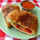 <p>Meet pizza's doughier cousin.</p>
<p><em>To make:</em><br />
1. Roll and stretch a handful of dough into 6-inch circle. Place 6 or 7 slices pepperoni and 3 tablespoons shredded mozzarella on one side of circle, leaving 1/4-inch rim (fill generously with pepperoni, the cheese will melt and leave a gap).<br />
2. Fold other half of dough over filling. Pinch edges to seal tightly. Roll edges in towards filling and pinch tightly again. Repeat with more dough and filling, as desired.<br />
3. In 12-inch skillet, heat 4 cups canola oil until hot, but not smoking. Adding only 2 calzones at a time, fry calzones 6 to 8 minutes or until deep golden brown on both sides, turning them over once. Cool slightly. Serve warm with marinara sauce.</p>