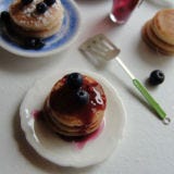 <b>The Artist:</b> Kim Saulter, <a href="http://kimsminiatures.blogspot.com/" target="_blank">It's a miniature life</a><br /><br />

Can you believe those fluffy, lightly-browned pancakes and plump, sweet blueberries are actually made out of clay? Kim Saulter started making dollhouse miniatures more than 20 years ago after her first daughter was born. Three years ago she jumped into the world of food miniatures, and she hasn't looked back since. On her blog you'll find recreations of cakes, cookies, pies, muffins, doughnuts, and other treats.