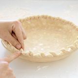 With kitchen shears, make diagonal cuts, 1/2 inch apart, around edge of crust to rim of pie plate. Using index finger and thumb of one hand, gently pinch each cut piece and alternately point toward center and rim.