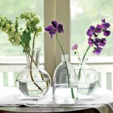 Spirited trio: Simple vessels gain impact in odd-numbered multiples, for a tablescape or a mantel. These three glass decanters get repurposed to form a simple yet sophisticated arrangement. The result? Single stems of oakleaf hydrangea and sweet peas feel as pleasing as a lavish bouquet.