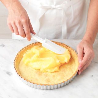 <p>Spread the lemon filling evenly into the cooked and cooled pie shell. A spatula is the best implement to use for this.</p>