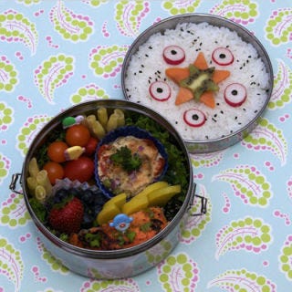 Radish slivers moonlight as octopus slices beside miso salmon and yellow wax bean "coral" in this trompe l'oeil bento.