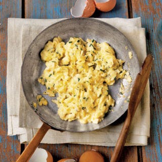Scrambled Eggs with Chives To make fluffy scrambled eggs, cook over low heat in a small amount of butter or extra-virgin olive oil; gently stir with a heat-resistant spatula for soft curds.