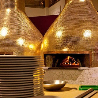 Eataly; New York City A partnership with the Naples-based restaurant chain Rossopomodoro, La Pizza at Mario Batali's sprawling Italian market uses a fornodoro (golden oven) designed by the Italian artist-architect-designer Riccardo Dalisi. The wood-fired oven, which is kept at a constant temperature of 800 degrees, has a cooking surface made from volcanic stone that originated near Mount Vesuvius. The oven bakes six pizzas at once; the pies are available adorned with classic Italian toppings like quality anchovies, fresh mozzarella and house-made sausage. Must try: The umami-packed Capricciosa, topped with mozzarella, mushrooms, prosciutto cotto, artichokes, tomato sauce and olives.
<br /><br />
<a href="eataly.com" target="_blank">eataly.com</a>