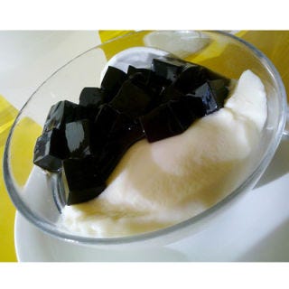<p>Grass jelly (also sometimes called leaf jelly)is made from the stalks and leaves of a plant related to mint. It's often served with other ingredients or as a component to a dessert, rather than on its own — here, it's pictured atop a bed of sweet tofu. </p>