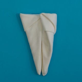 Roll the left side over, slightly past the center of the napkin.