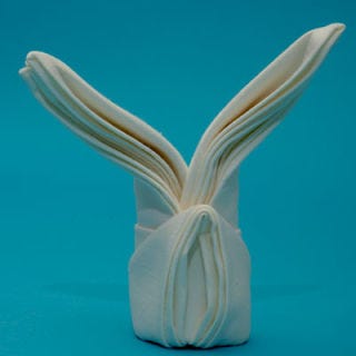 Turn the napkin upright, separating the bottom to form a base. Fluff your bunny's ears.