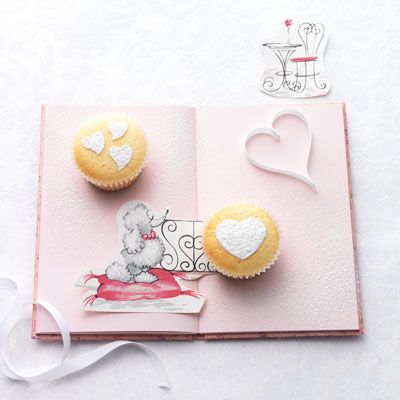 <p>Use a hard plastic stencil that has varying sized and shaped hearts. Working with one cake at a time, place the stencil on the top of the cake, use a fine sifter to sift powdered sugar over the cut-out shapes. Gently lift the stencil off the cake. Brush the excess sugar from the stencil before using on the next cake.</p>