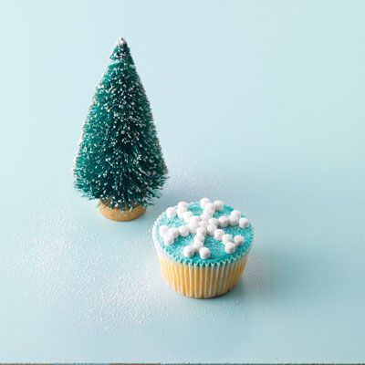 <p>Color butter cream blue. Spread the top of each cake evenly with the butter cream. Gently push mini mints into the butter cream in the shape of snowflakes. Dust cakes with sifted powdered sugar.</p>