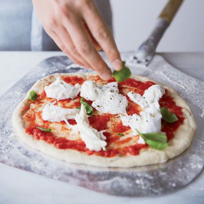 <p>When topping pies like this Margherita, less is more, especially with sauce.</p><p><b>Recipe: </b><a href="/recipefinder/margherita-pizza-tomato-mozzarella-basil-recipe-fw0413" target="_blank"><b>Margherita Pizza with Tomato, Mozzarella and Basil</b></a></p>