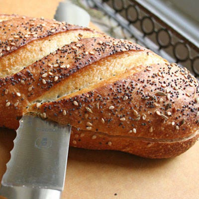 <b>Cut the Baguette</b>

Use a sharp bread knife to cut the baguette across the center of its horizontal axis. For an even cut across, place your left hand flat and firmly down on the top of the baguette, and begin sawing the middle of the baguette with the knife in your right hand.

Here's another helpful tip for getting an even cut: bend down so the knife is at your eye level, and always make sure the knife is parallel with the cutting board as you cut.