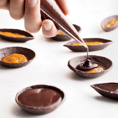 For more precise applications, such as filling tartlets, use a disposable pastry bag with a small opening, which will provide control as you pipe the liquid. 
