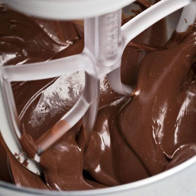  When beaten at room temperature, ganache fluffs up like whipped cream (which, given its heavy-cream content, makes perfect sense). For a smoother and denser frosting, whip the ganache less; for a fluffier, lighter one, whip it longer.
