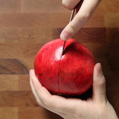 Score the skin along each bulbous ridge of the fruit. Avoid cutting into the seeds. This will make breaking open the fruit easier in order to access the seeds, and is less damaging than if you simply quartered the fruit.