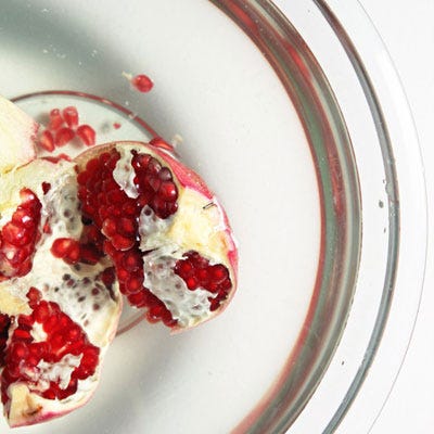 Gently but firmly tease the seeds away from the membrane and pomegranate flesh underwater. The membrane bits and damaged seeds will float to the top, while the denser whole seeds will sink to the bottom of the bowl.