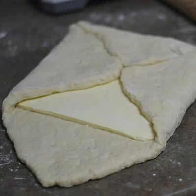 Now the fun part begins — and get out your tape measure! To get those flaky layers of dough, we had to incorporate a lot of butter. Wrap the butter up with the dough like a little present.