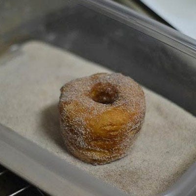 We don't just stop there, though. To finish the cronut exactly like Ansel does, we rolled ours in a mixture of cinnamon and sugar. This is best done when the cronuts are still warm, but the excess oil has been absorbed with a paper towel.