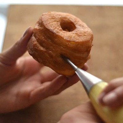 And just like Ansel does as well, we filled ours with a vanilla cream. Inject the cream into the cronut in a few different spots to ensure that the cream is dispersed throughout.