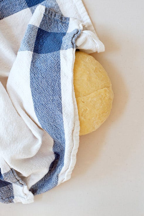 <p>Let the dough rest for at least 15 minutes under a clean dish towel. This allows the moisture from the eggs (and water, if needed) to distribute throughout the doughy mass, making it easier to work with.</p>