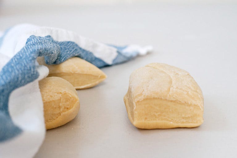 <p>Use a bench scraper to divide the dough into six even portions. Work with one chunk of dough at a time, covering the rest with the dish towel so that they won't dry out. </p>
