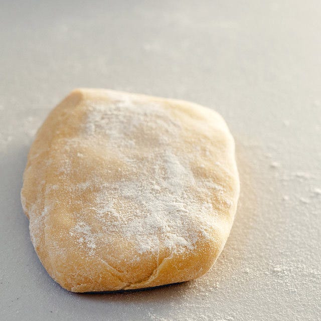 <p>Lightly dust the piece of pasta dough with flour and pat it out into a 1/2-inch thick rectangle.</p>