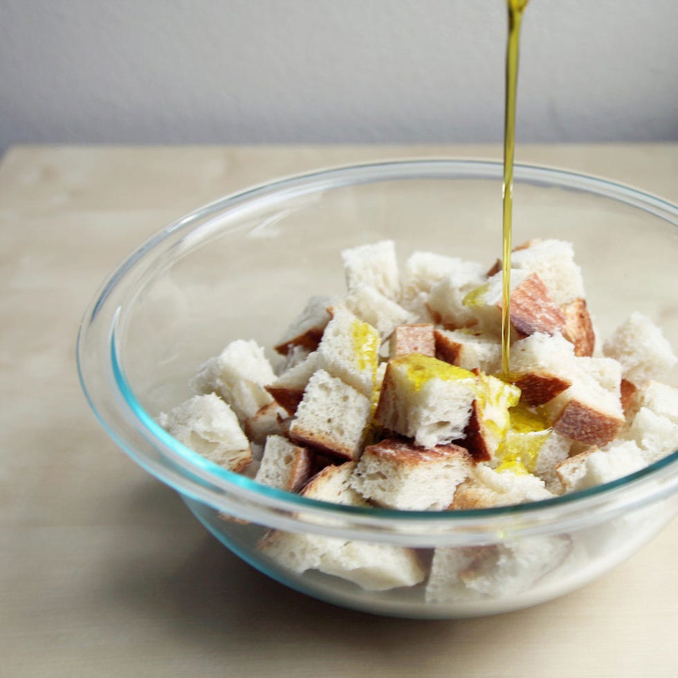 For every two slices worth of bread cubes, drizzle 1 tablespoon of olive oil over the bread and toss with your hands to coat. Season to taste with kosher salt (the bread should taste slightly salty) and add fresh or dried herbs, if desired. For dried herbs (such as herbes de Provence), add 1/4 teaspoon per two slices worth of bread. For fresh herbs (such as minced thyme or rosemary), add 1/2 teaspoon per two slices worth of bread.