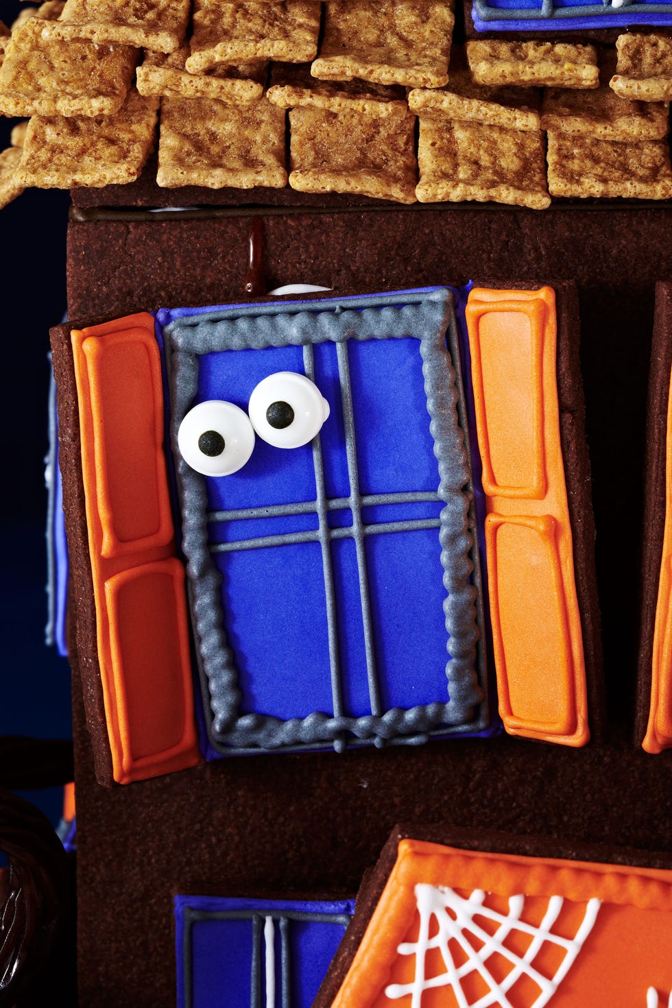 <p>Attach windows to house with royal icing, then affix candy eyeballs ($3.99; <a href="http://www.wilton.com/" target="_blank">Wilton.com</a>) to windows with melted hard caramel.</p>